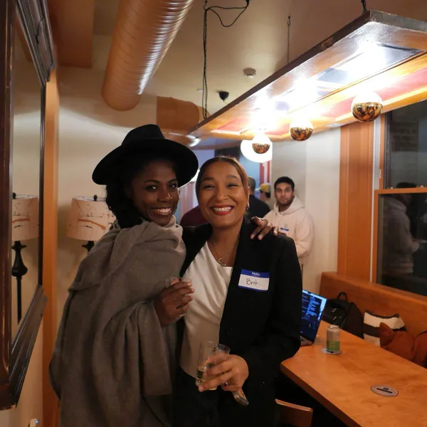 Two attendees in a candid moment at an AI Build Club event, February 2026