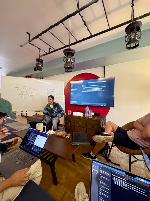 Nadeen leading a discussion circle while attendees build on laptops at the August 2026 Claude Code Workshop