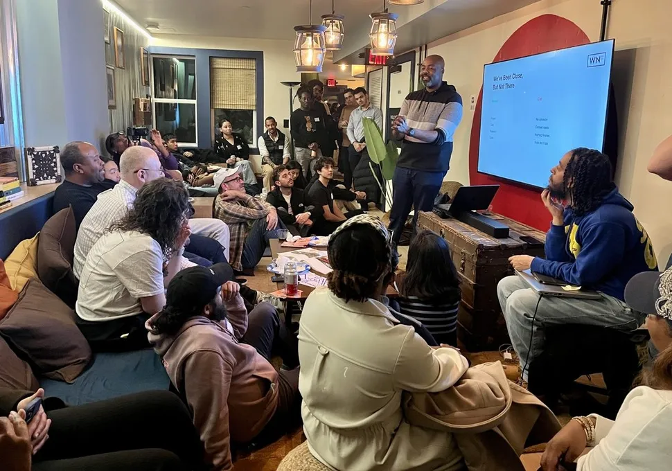 A packed living room of attendees at the March 2026 AI Build Club event